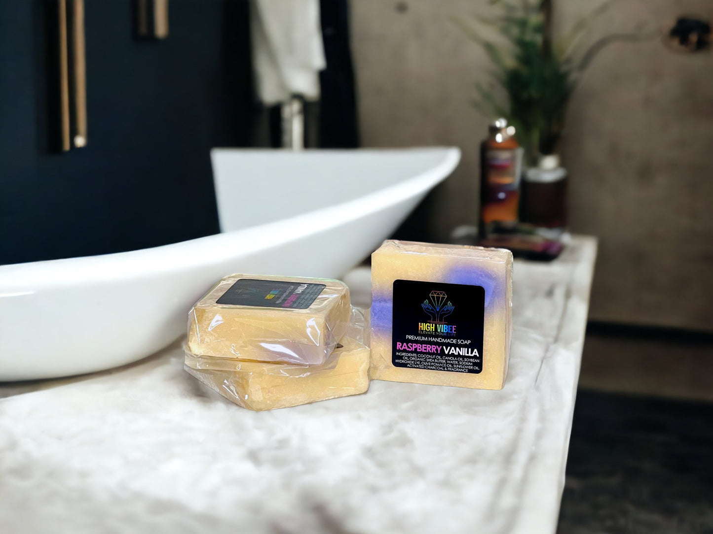 In the photo, there is the “Raspberry Vanilla” High Vibee Soap. The soap is a creme color with hints of purple. The photo shows three of these soaps on top of a cloth on a beautiful bathroom counter.