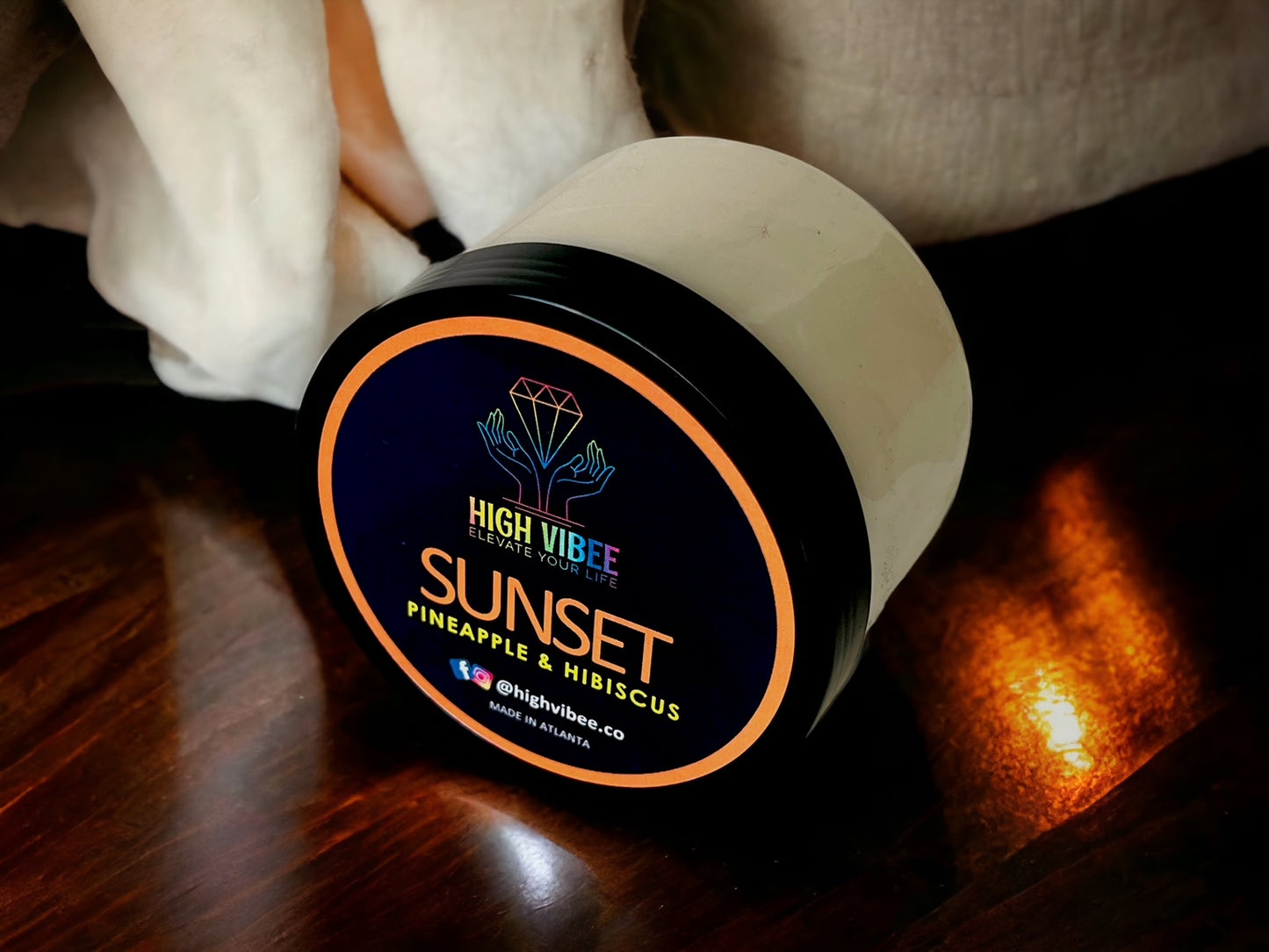 In this photo, there is a jar of High Vibee's “Sunset” Body Butta scented with Pineapple & Hibiscus.