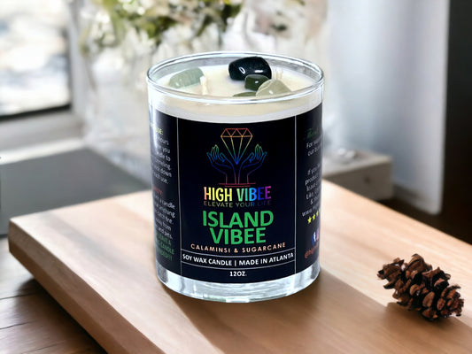  In this photo, there is a jar of High Vibee's “Island Vibee” 12oz. Candle, scented with Calamansi & Sugarcane. In the photo, the top is off of the candle, and there are two wicks along with green, clear and black crystals inside.