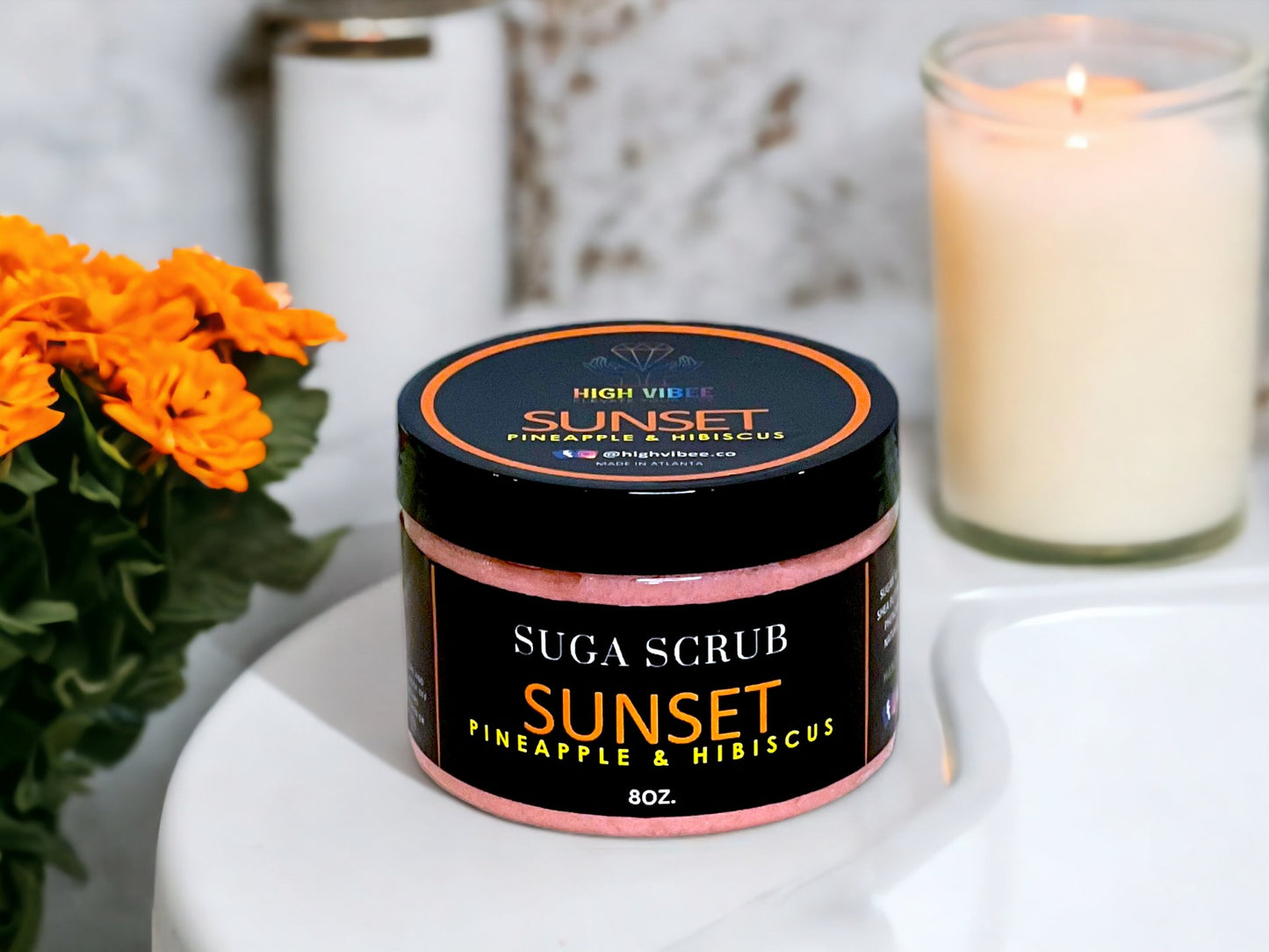 In this photo, there Is a jar of “Sunset” Sugar Scrub, scented with Pineapple & Hibiscus.