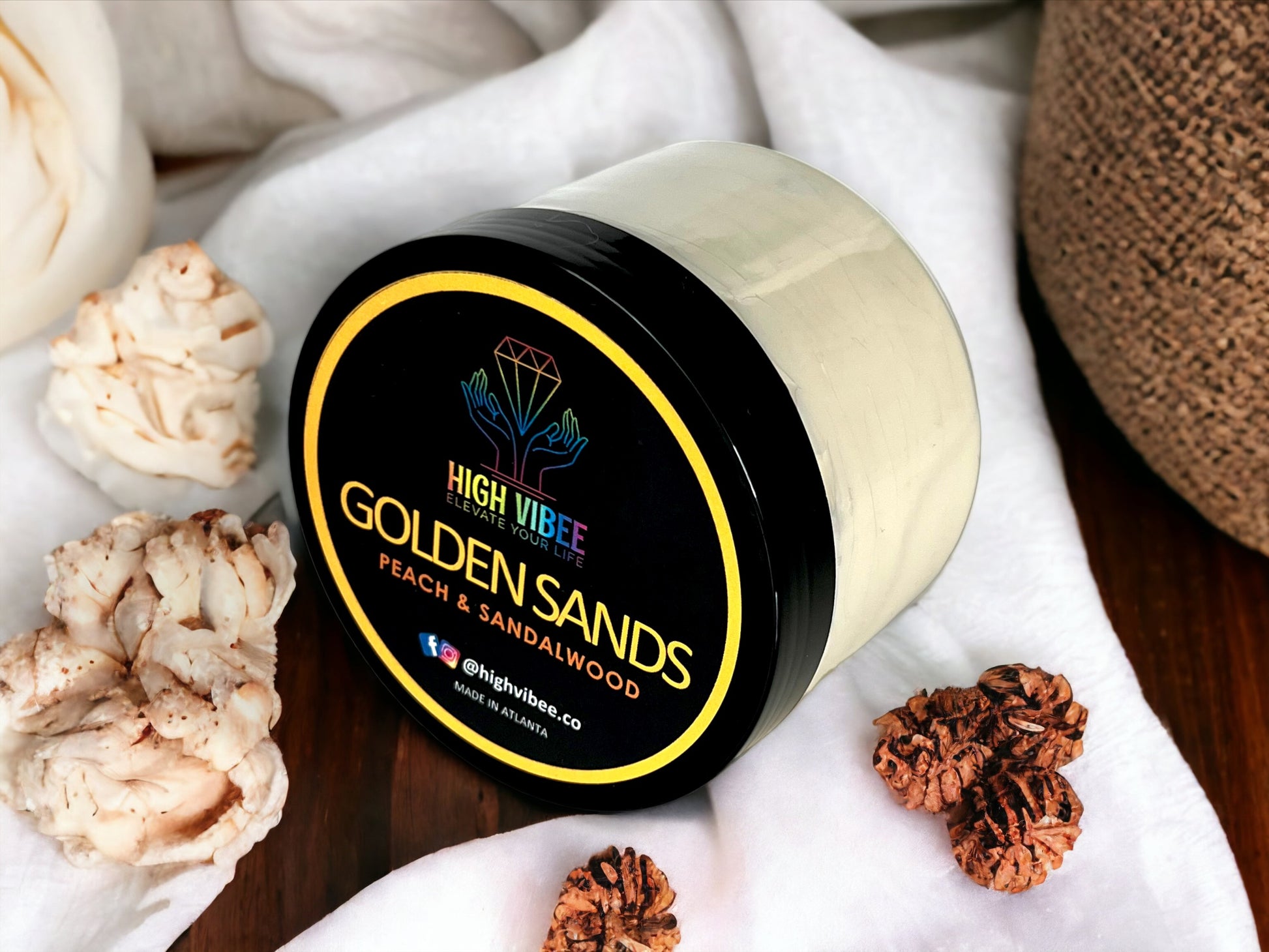 In this photo, there is a jar of High Vibee's “Golden Sands” Body Butta scented with Peach & Sandalwood.