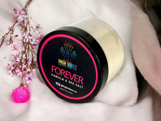 In this photo, there is a jar of High Vibee's “Forever” Body Butta scented with Vanilla & Sea Salt.